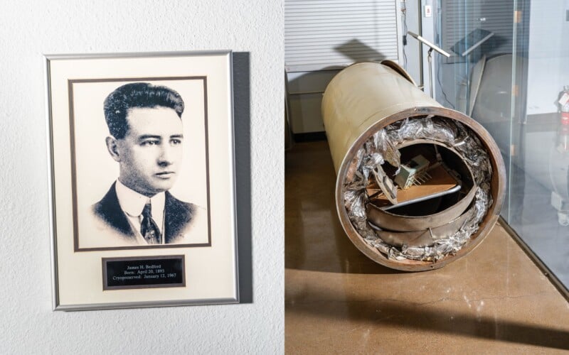 A framed black and white portrait of a man next to a damaged cylindrical time capsule with its contents visible, sitting on a concrete floor against a white wall.