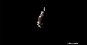 Image of a satellite in space against a dark background, captured by astroscale, showing detailed parts reflecting light.