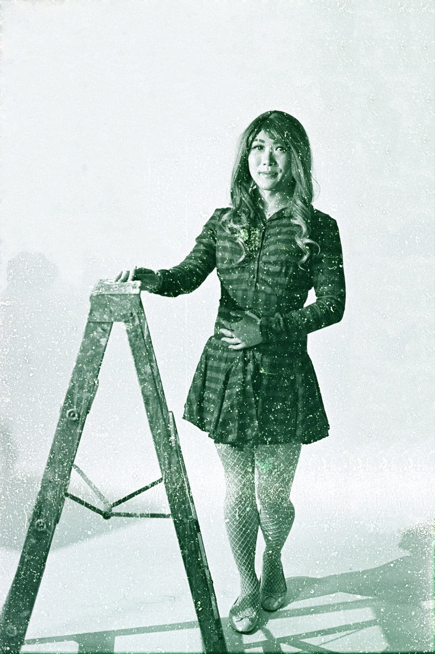 A woman in a vintage outfit, standing next to a ladder, with a textured, old-fashioned photo effect.