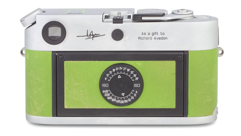 Leica M6 camera with a green leather case and silver top with a dial and controls for settings. there's an engraving that reads "As a gift to Richard Avedon.