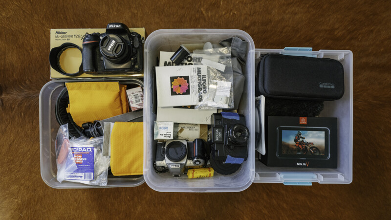 Plastic bins are filled with photography gear.