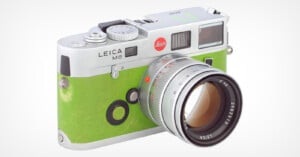 A Leica M6 camera with a vibrant green leather covering and a silver 50mm lens attached, isolated on a white background.