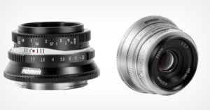 Two camera lenses are shown against a gray background. the left lens is black with white markings, and the right lens is silver with red and white markings.