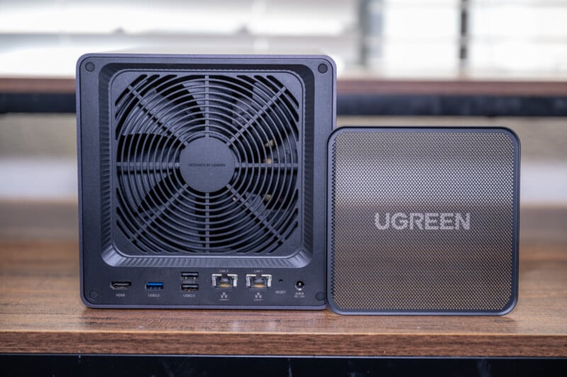 A ugreen branded portable electronic device and a larger device with a prominent cooling fan on display on a wooden surface.