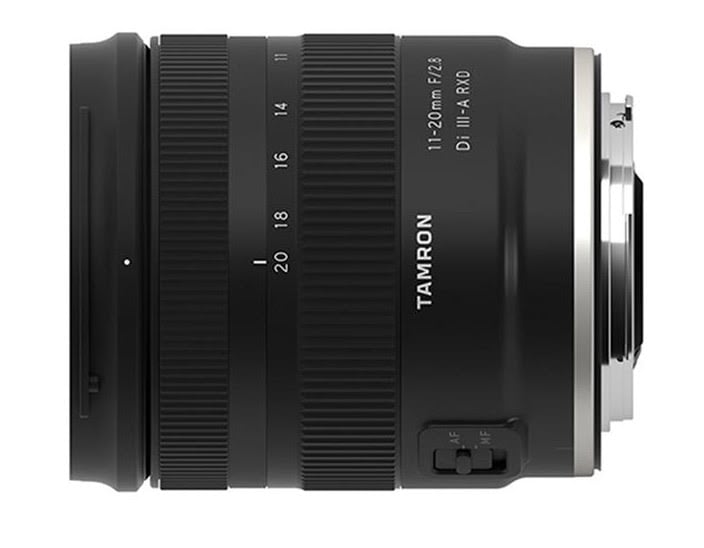 A black tamron camera lens, model 11-20mm with a f/2.8 aperture, displayed from the side showing focus and zoom rings and mount connection.