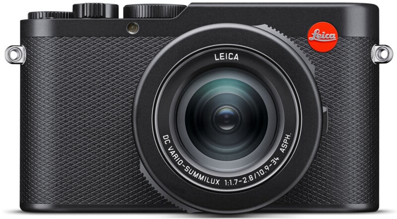 Front view of a black Leica digital camera with a textured grip. The lens reads "DC VARIO-SUMMILUX 1:1.7-2.8 / 10.9-34 ASPH." The top left features control dials, and the top right has a red Leica logo.
