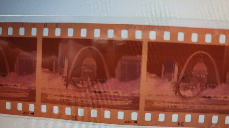 Film strip showing a repeated pattern negative image of a vehicle, displayed in a reddish hue against document background.