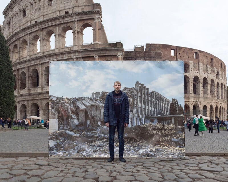 A person stands in front of the Colosseum, positioned in the middle of a large photograph depicting a modern building in ruins. The juxtaposition contrasts the ancient Roman architecture with contemporary destruction. People and trees are visible in the background.