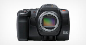 A high-resolution, black digital camera with a visible lens mount and a textured grip on the left side. The camera body shows "Blackmagic Design" branding and "6K Full Frame" marking on the front. The camera has several buttons and controls on its exterior.