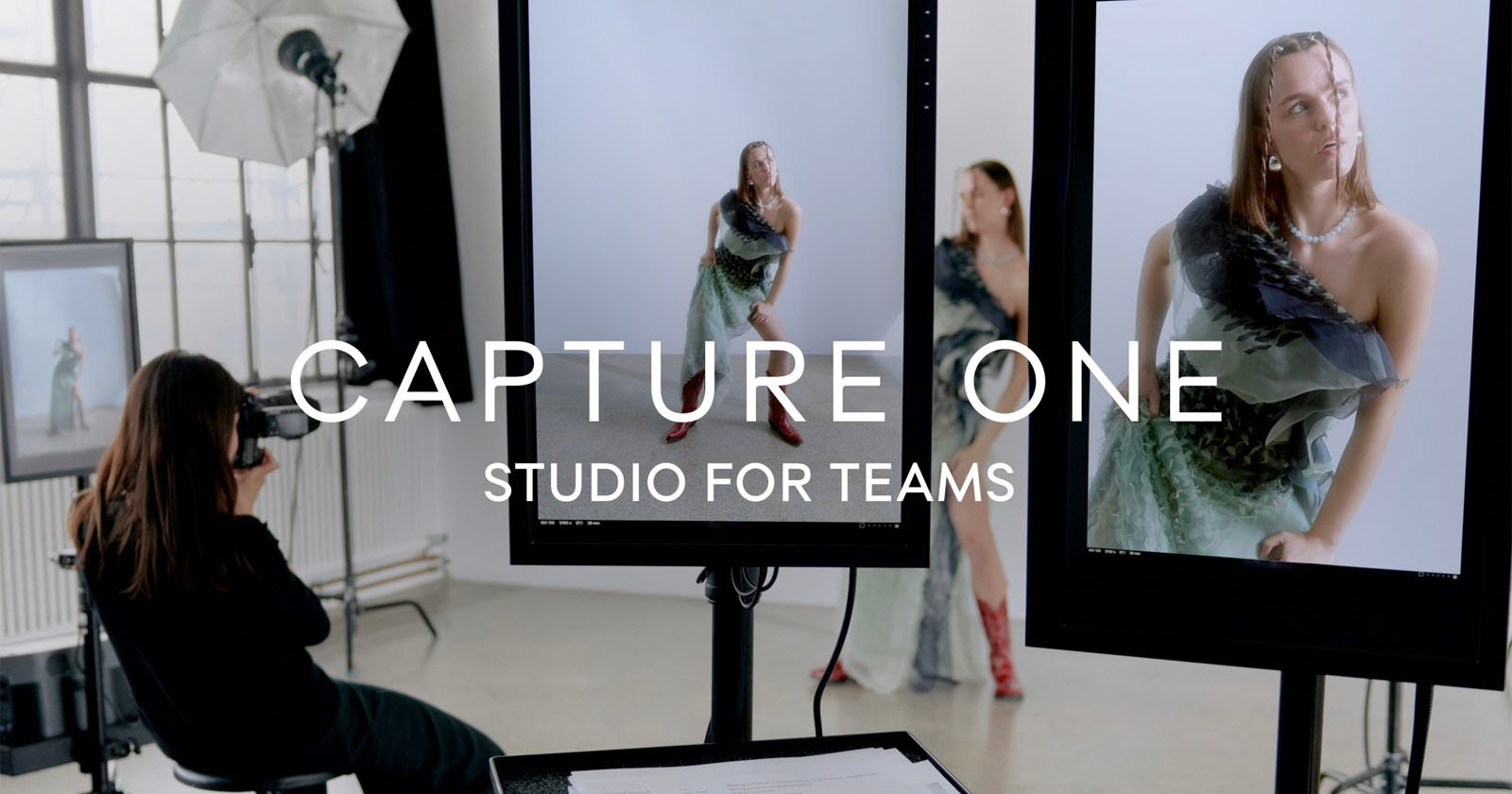 A photographer works in a studio, using a camera and digital screens to capture images of a model posing in stylish outfits. The text CAPTURE ONE STUDIO FOR TEAMS overlays the image. The scene is well-lit and features professional photography equipment.