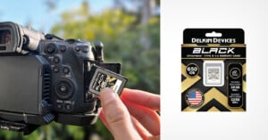 A person's hand inserting a delkin devices black cfexpress type b 650gb memory card into a digital camera, with the memory card's packaging shown on the right.
