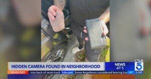 A man holding a rock and a smartphone with a news headline overlay about a hidden camera found in a neighborhood.