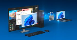 Illustration of a secure data transfer between a desktop computer and a laptop. The desktop monitor shows various software windows, while a padlock icon with digital connections symbolizes secure transfer to the laptop. Both devices display the same abstract image.