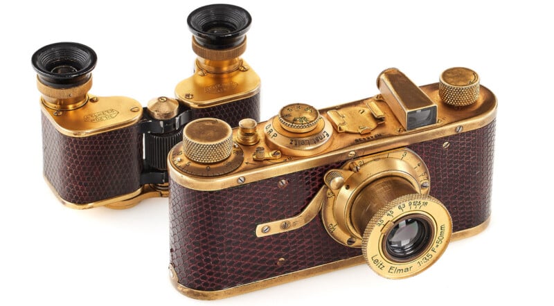 Vintage gold-plated leica camera with matching binoculars, featuring intricate detailing and textured surfaces, displayed on a white background.