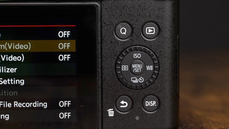 Close-up of the back of a camera showing the control dial, buttons, and part of the menu screen. The menu options include "Film(Video)" and "File Recording," both set to "OFF." The control dial features buttons for ISO, MENU/SET, and WB (white balance).