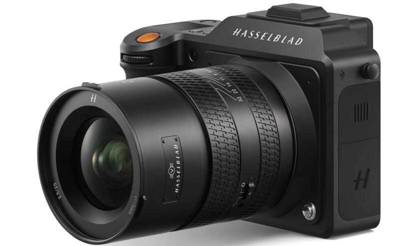 A hasselblad mirrorless digital camera with a large lens, showcasing detailed focus rings and branding on a plain white background.