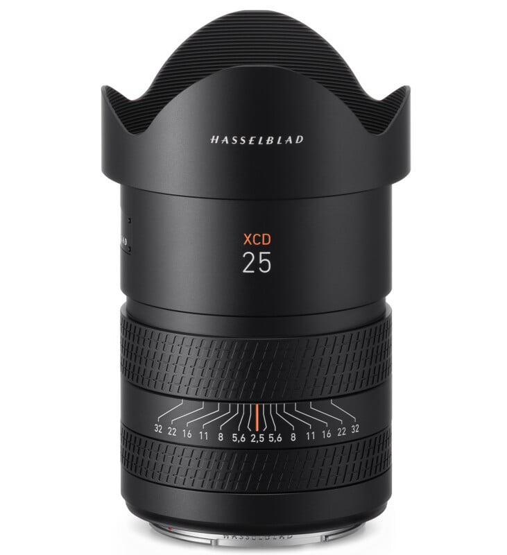 Obiettivo per fotocamera Hasselblad XCD nero da 25 mm con anelli di messa a fuoco e apertura, visto di lato su uno sfondo bianco.  Il paraluce è fissato nella parte superiore.