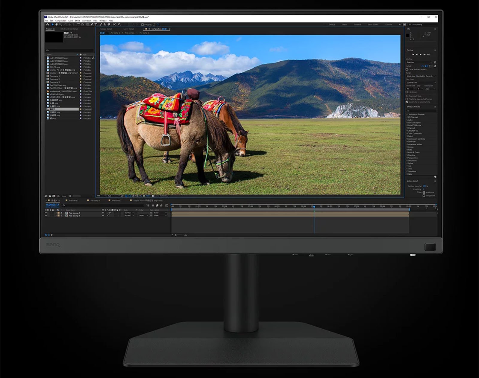 A computer monitor displaying a photo editing software interface with an image of two horses saddled with vibrant textiles in a scenic grassy field against a backdrop of mountains.