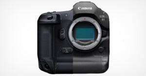 A Canon EOS R1 camera body is displayed against a white background. The camera features a textured grip on the left side and a clean, smooth surface on the right side. The lens mount and sensor are visible.