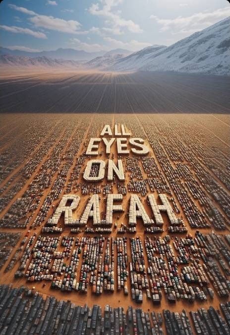 A vast desert landscape with clustered parked vehicles forming the large words "ALL EYES ON RAFAH," stretching from the foreground to the background. Snow-capped mountains rise in the distance under a partly cloudy sky.
