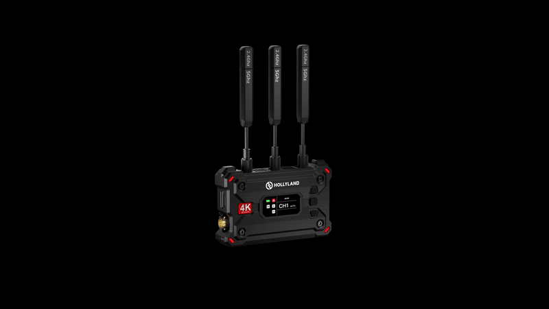 A wireless video transmitter with three antennas, labeled "HOLLYLAND" on each. The front panel displays a small screen and several buttons, with a 4K label indicating high-definition capability. The device has a black and red design and is set against a black background.