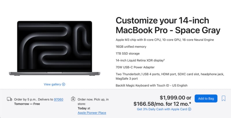 Advertisement for a 14-inch space gray macbook pro showing the laptop with a stylized desktop wallpaper. includes specs such as 8-core cpu, 14-inch retina display, and pricing details at $1,599.00.