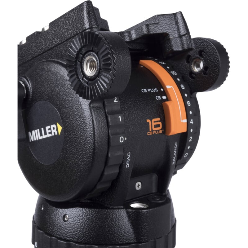 Close-up of a miller professional video camera head showing detailed features and adjustment knobs, predominantly black with parts in orange.