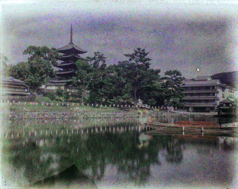 Vintage-style photo of a serene landscape featuring a traditional multi-tiered pagoda near a calm lake with lush trees and modern buildings in the background.