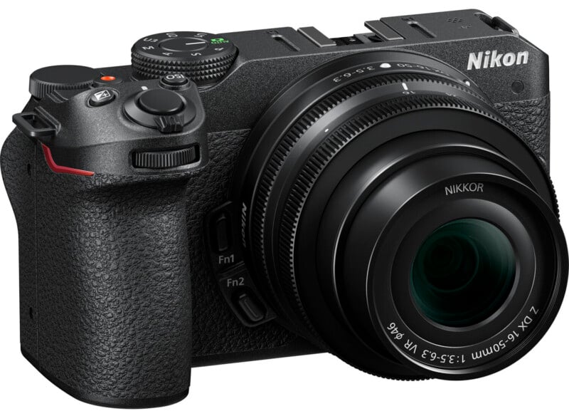 A nikon mirrorless camera with a large lens, featuring prominently positioned control dials and labeled buttons, against a white background.