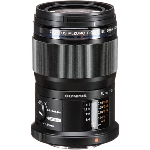 A close-up photo of an olympus m.zuiko digital ed 60mm f2.8 lens, showing detailed markings and settings on the cylindrical black body.