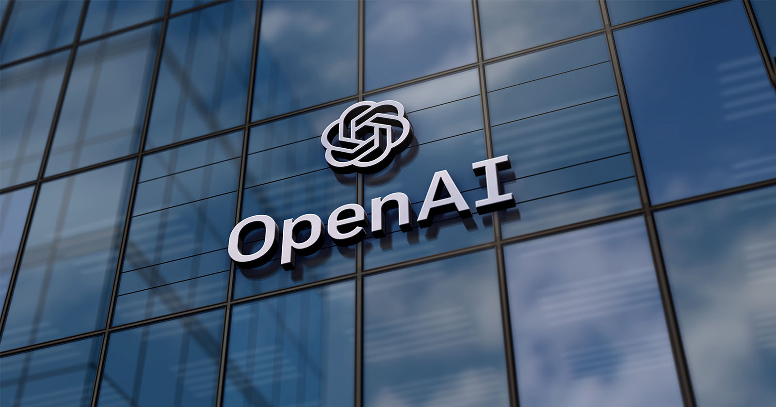 A 3d-rendered image of the openai logo, which consists of interlocking circles and letters, mounted on the exterior of a modern glass building under a clear blue sky.