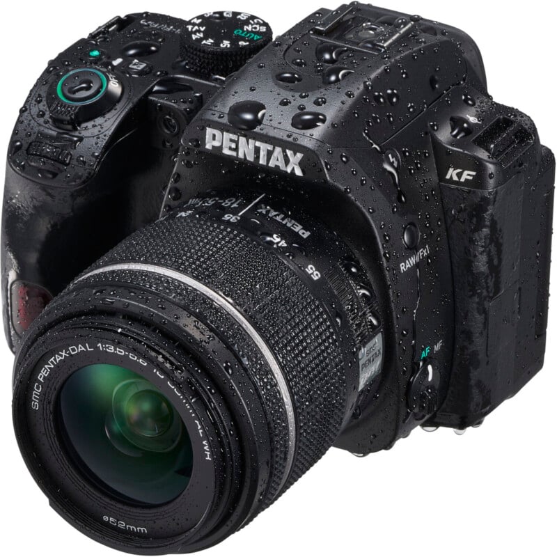 A close-up of a wet black pentax dslr camera with a zoom lens. the camera is speckled with water droplets, emphasizing its waterproof feature.
