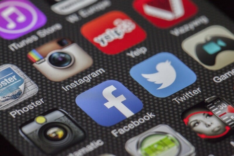 Close-up of a smartphone screen displaying various social media app icons including instagram, facebook, and twitter, showing vibrant colors and details.