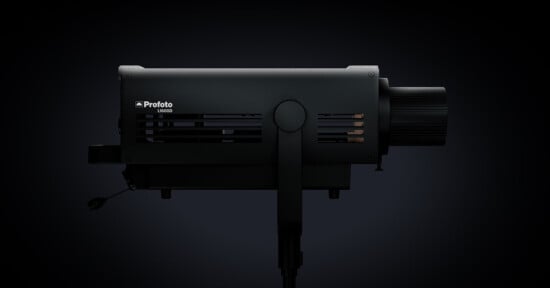 A side view of the Profoto B10x flash unit against a dark background. The flash unit is mounted on a stand and features a cylindrical body with vents and a large knob at the back for adjustments. The brand name "Profoto" and model "B10x" are visible.