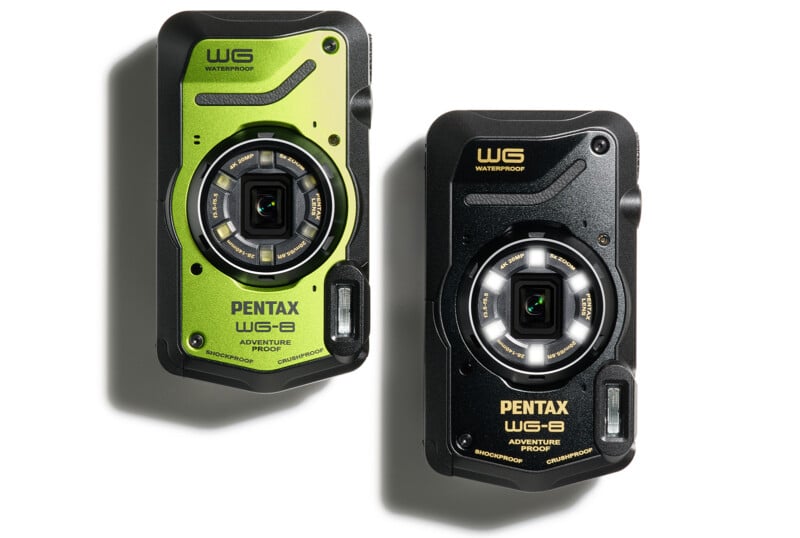 Two Pentax WG-8 adventure-proof digital cameras are displayed. One is green and the other is black. Both are labeled "waterproof" and feature a rugged design with prominent lenses. The green model is on the left and the black model is on the right.