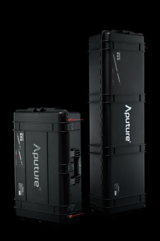 Two black Aputure carrying cases stand against a black background. The case on the left is shorter and has a handle on its side; the case on the right is tall and narrow. Both cases have the Aputure logo prominently displayed on their sides in white letters.