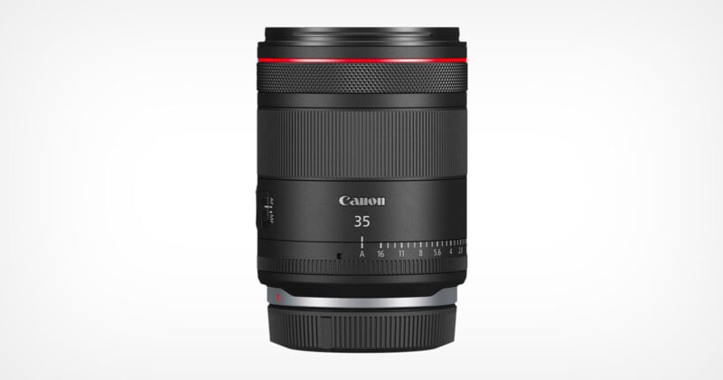 A Canon 35mm camera lens with a sleek black design. The lens features a red ring near the top, a focus adjustment ring, and a control ring. The brand name 