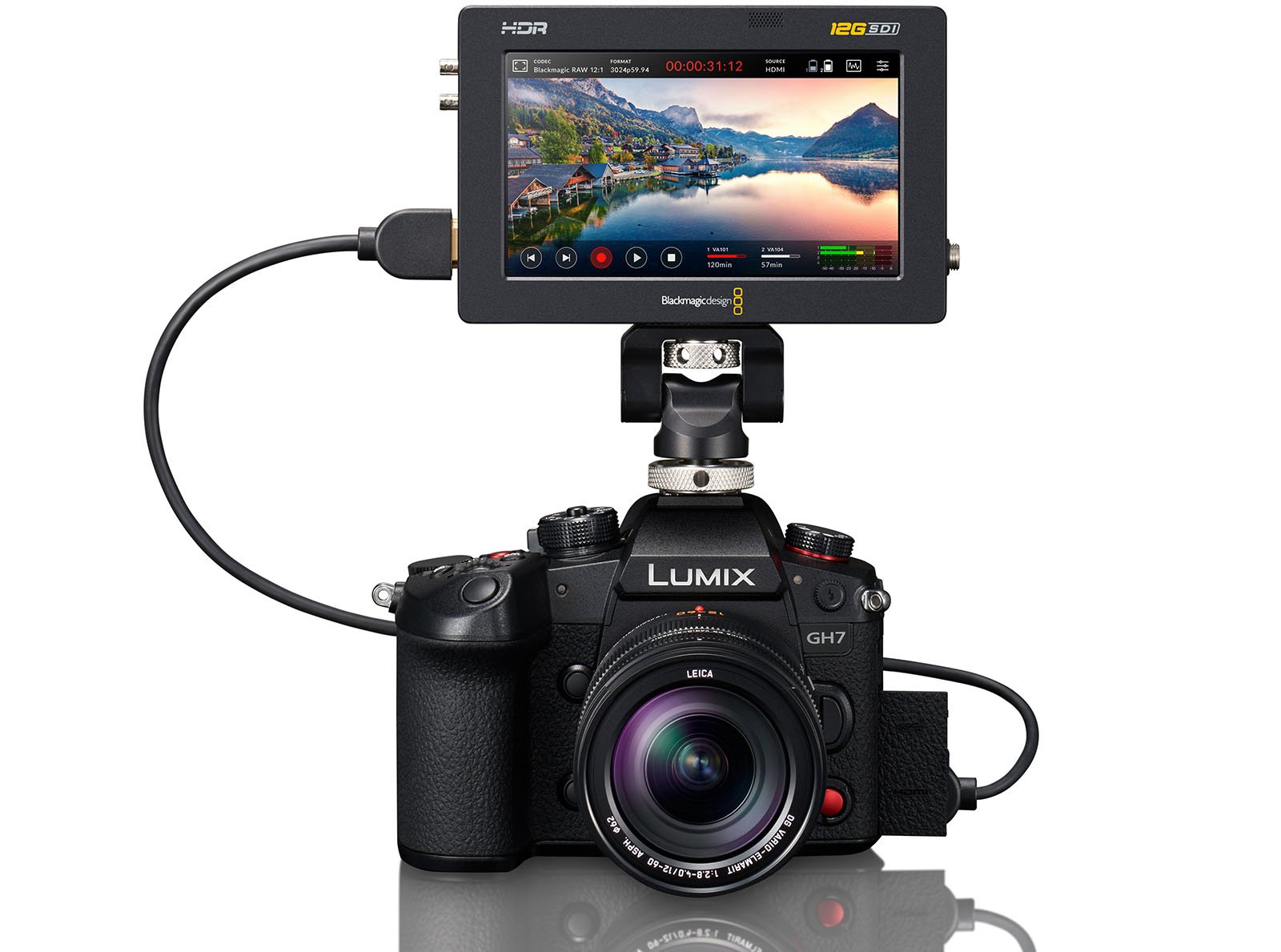 A Lumix GH7 camera is outfitted with a Leica lens. Mounted on top of the camera is a Blackmagic Design HDR screen displaying a vibrant landscape scene, connected via a cable. The setup appears to be configured for professional video recording or photography.