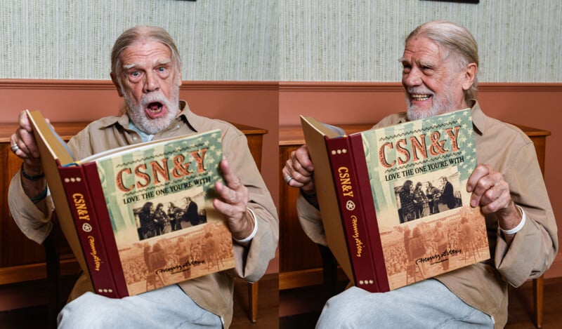 Two side-by-side images of an elderly man with a long white beard and hair, wearing a beige shirt. In the left image, he looks surprised while holding a large book titled "CSN&Y: Love the One You're With." In the right image, he smiles warmly at the book.