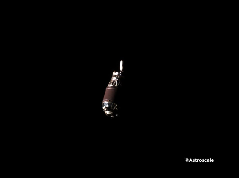 A spacecraft, illuminated against the vast darkness of space, is positioned centrally in the image. A logo in the lower right corner reads "Astroscale.
