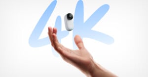 A person's hand is tossing a small, white action camera with a lens, set against a white background. Behind the camera, the text "4K" is prominently displayed in large, blue letters. The image highlights the camera's ability to capture 4K resolution video.