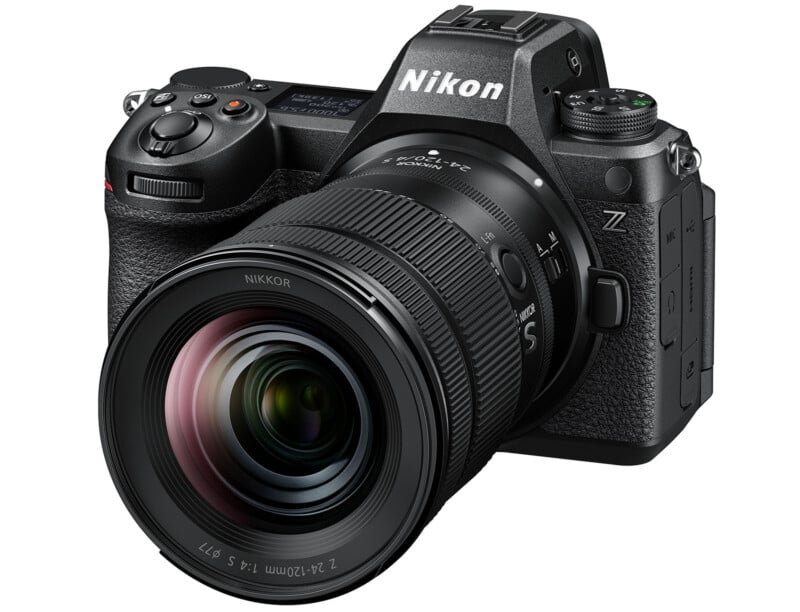 A Nikon Z series mirrorless camera with a zoom lens attached. The camera features various control buttons, dials, and an electronic viewfinder. The lens has markings indicating it is a NIKKOR Z 24-70mm f/2.8 S lens. The camera is black in color.