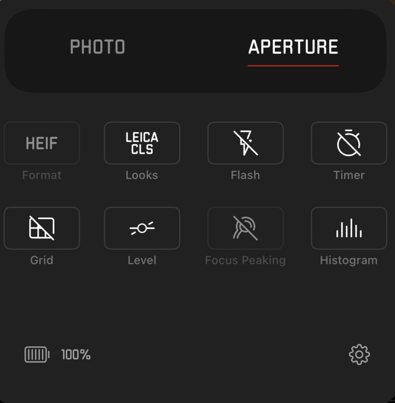 The image shows a camera settings menu with 'Aperture' selected. Options displayed include HEIF format, LEICA CLS looks, flash, timer, grid, level, focus peaking, and histogram. A battery indicator at the bottom left reads 100%.