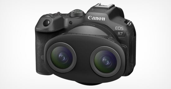 A Canon EOS R7 camera with an attached dual fisheye lens. The camera has a black body with multiple control dials and buttons, and the lens consists of two large, protruding circular elements. The setup is displayed on a plain white background.
