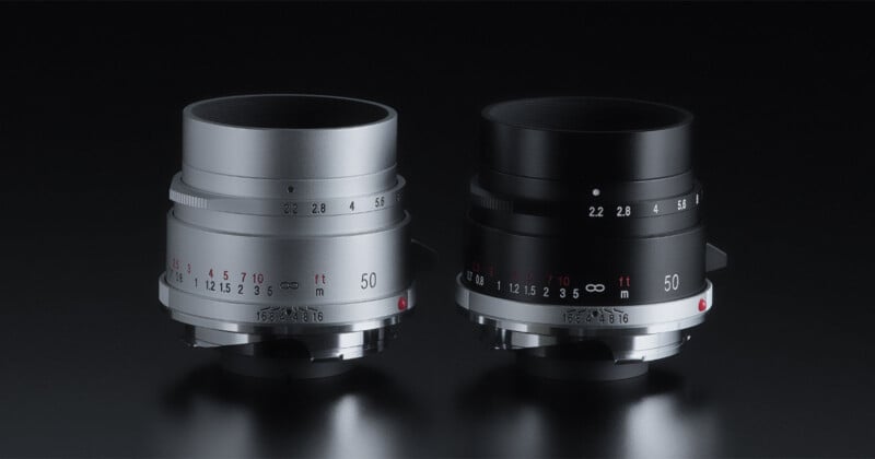 A sleek black camera lens sits next to an identical model in silver against a dark background. Both lenses feature various focus numbers and markings, showcasing their technical details.