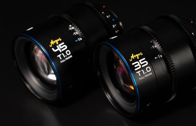 Two black camera lenses are shown on a dark surface. The lens on the left is labeled "Argus 45mm T1.0 Full Frame," while the lens on the right is labeled "Argus 35mm T1.0 Full Frame." Both lenses feature blue accents around the edge of the mounts.