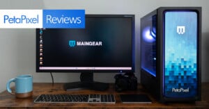 A desktop computer setup includes a monitor displaying "MAINGEAR" with the Petapixel logo above. Beside the monitor are a camera, a mug, and a keyboard on a wooden desk. A PC tower with blue gradient design and "Petapixel" branding is also present.