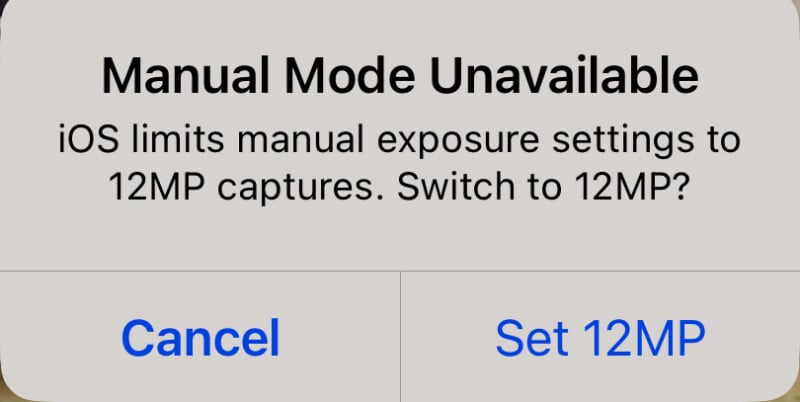 A pop-up message on an iOS device screen reads, “Manual Mode Unavailable. iOS limits manual exposure settings to 12MP captures. Switch to 12MP?” Below the message, there are two buttons: “Cancel” on the left and “Set 12MP” on the right.