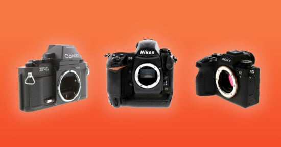 Three camera bodies displayed without lenses. From left to right: Canon film SLR, Nikon DSLR, and Sony mirrorless camera against an orange background. The Canon and Sony cameras show a partial view of their lens mounts.