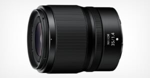 A black Nikkor 35mm f/1.4 camera lens is shown against a white background. The lens features a ribbed focus ring and the engraved text "Nikkor 35 1:1.4" near the front element.